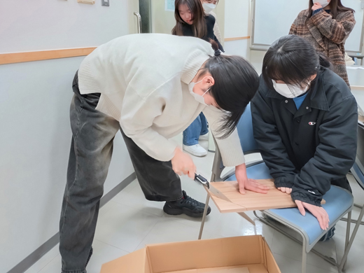 看板製作 のこぎりで板を切っています