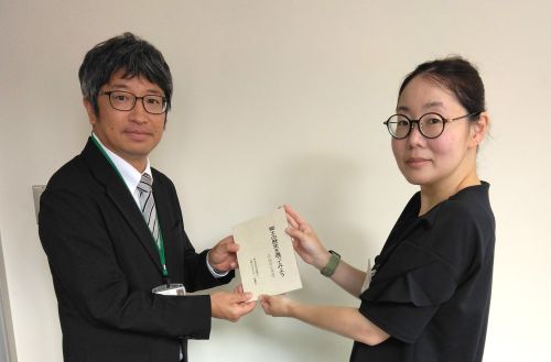 本を寄贈する小野木教授（写真左）