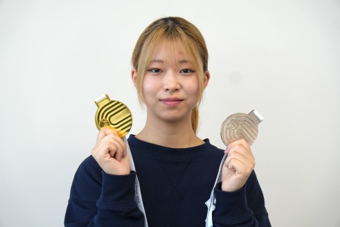 メダルを掲げる佐藤さん