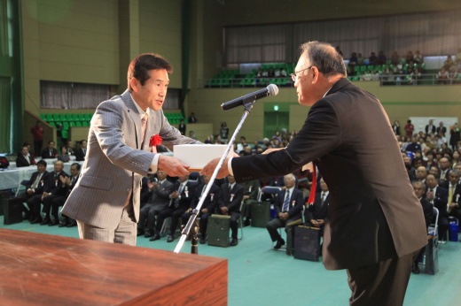 陸上競技部・広浦部長（左）は宇検村・元田信有村長から感謝状と記念品を受け取る（写真提供：宇検村役場）