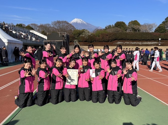 富士山をバックに8位入賞の賞状を手に笑顔の女子陸上競技部