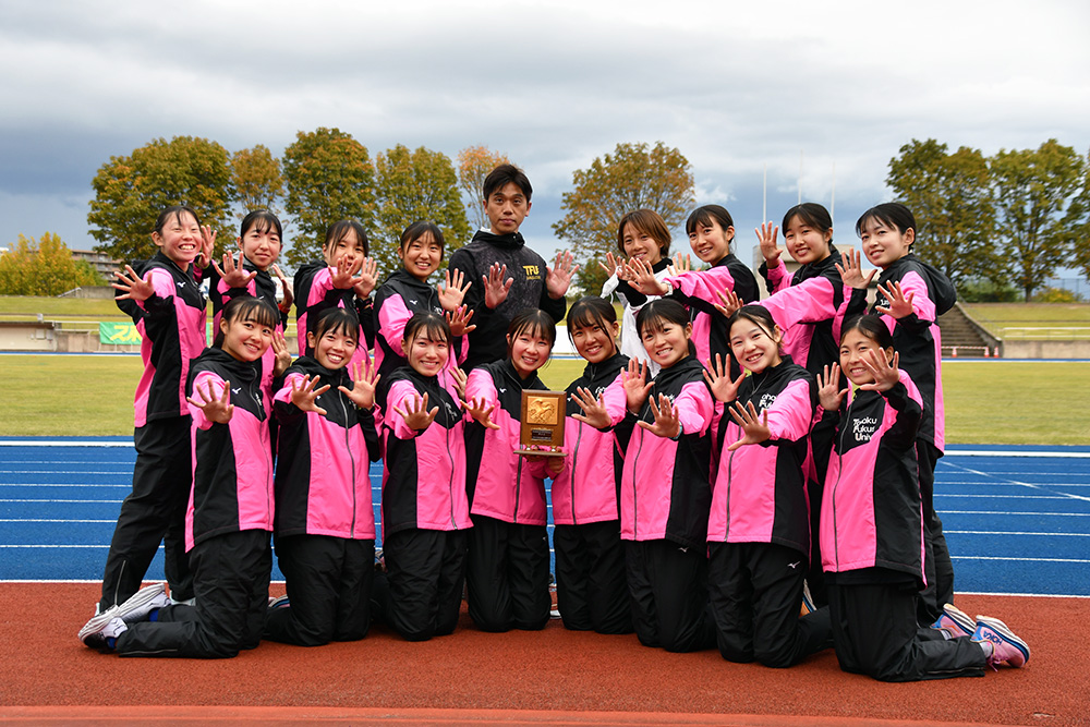 8位入賞の盾を手に笑顔の女子駅伝チーム