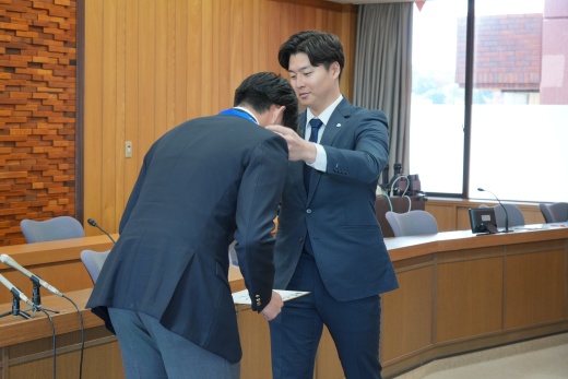 齊藤担当スカウトから会議で使用したIDを首にかけてもらう堀越投手