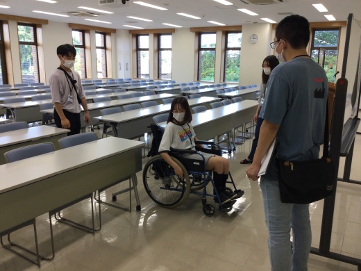 ステーションキャンパスの教室の中で車椅子が通れるか検証している様子です。