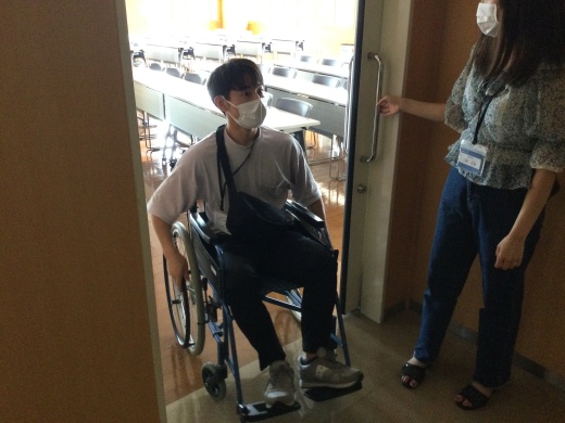 ステーションキャンパスの教室の出入り口で、車椅子が自分で出入りできるか検証している様子です。