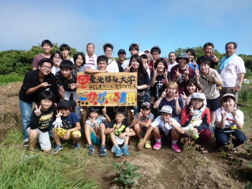 植樹したばかりのオリーブ農園で、真新しい手づくり看板を真ん中に記念撮影