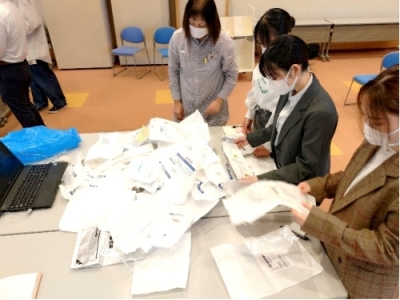 医療材料の管理方法について議論中(使用後の医療材料の梱包材を見ています)