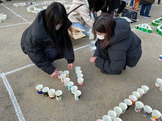 紙コップの中にキャンドルを入れ、地面に並べていきます
