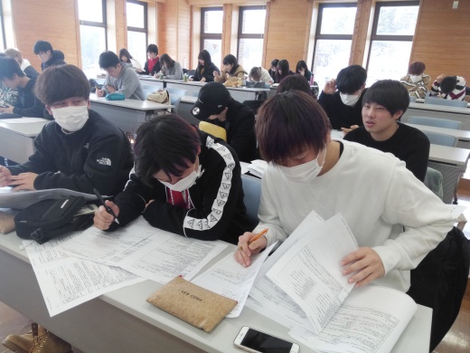配付されたシラバスを読み込みながら、所属ゼミについて検討する1年生たち