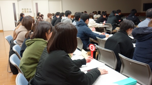 マル・バツの札を揚げる学生たち
