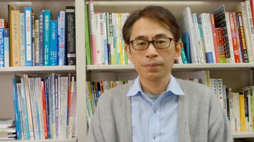 研究室の書架の前で