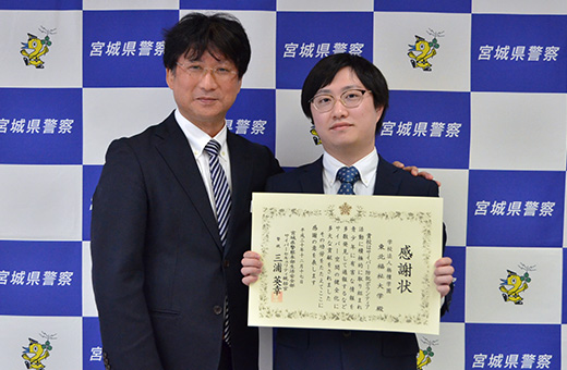 表彰状を手にした近藤さんと情報福祉マネジメント学科・大内誠学科長（左）