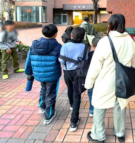 こどもたちと一緒に大学の中の会場まで歩いている様子