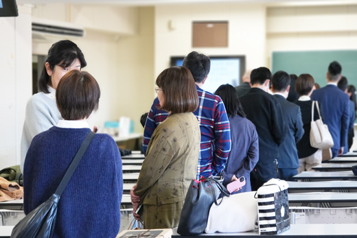 講義終了後に記念撮影のために列に並ぶ卒業生たち