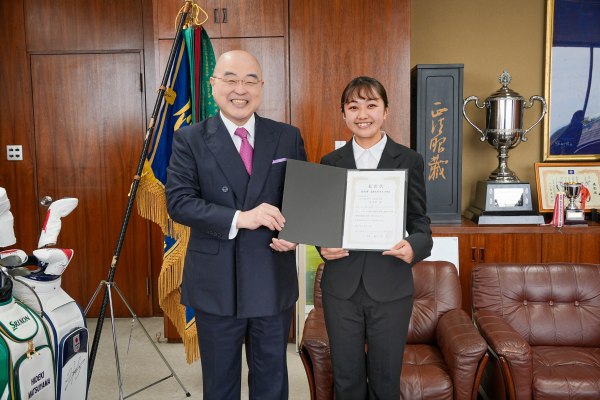 賞状を手に学長と笑顔で写る角さん（右）