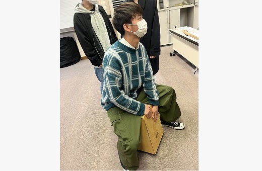 カホンを演奏する学生