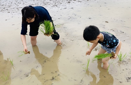 手植えをする子どもと筆者