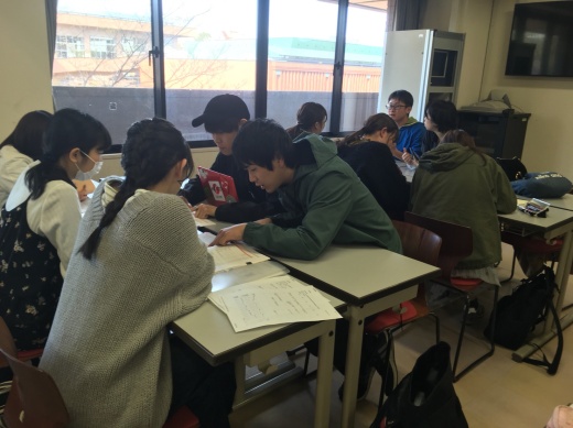 学生便覧を見ながら教えている様子