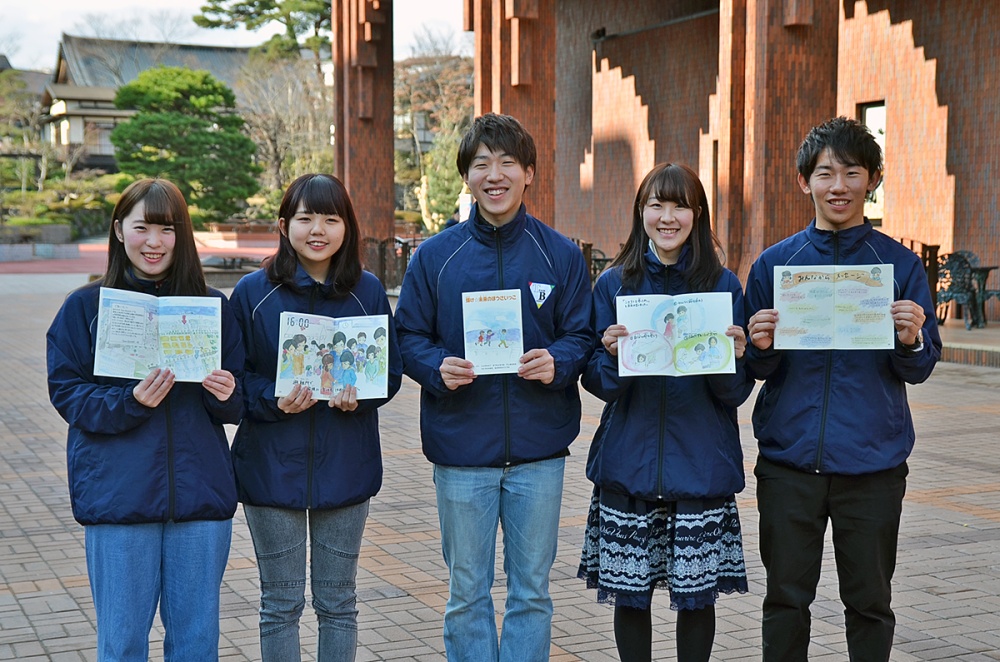絵本が完成し、手に持ち喜ぶ学生