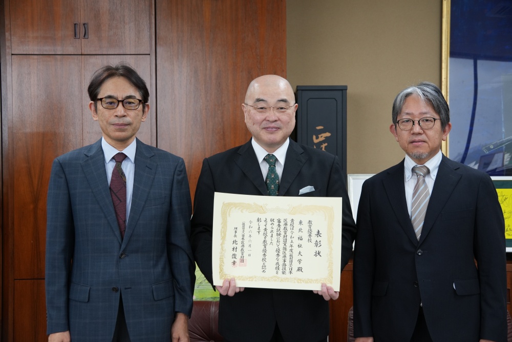左から冲永壯治医療経営管理学科長、千葉公慈学長、渡部芳彦教授