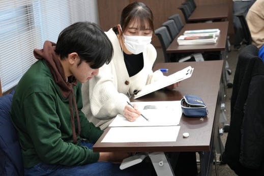 中学生の質問に対して丁寧に答える学生