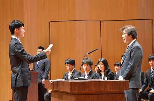 体育会・松江会長に、新入会員として誓いの言葉を述べる男子卓球部の野宮さん(左)
