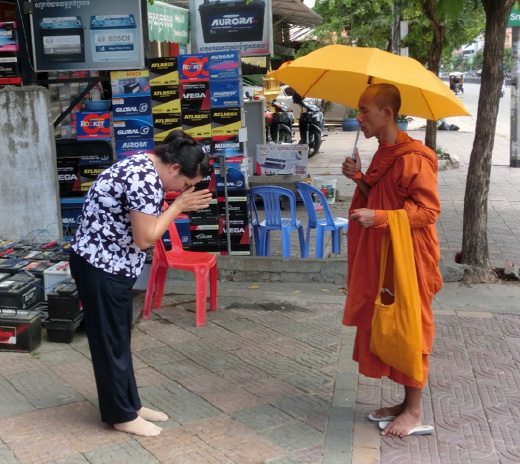 托鉢を行う僧侶に祈りを捧げる市民の光景は、プノンペン市内の日常風景