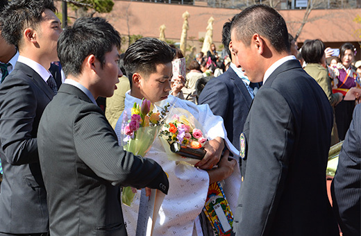 後輩から花束を渡される比嘉さん(中央)