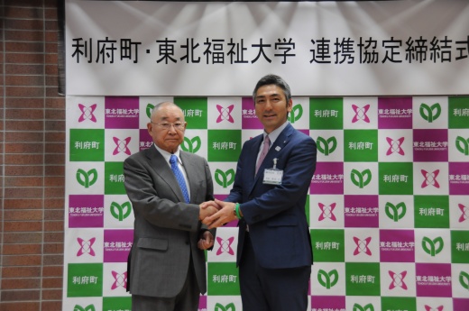 協定を結び握手を交わす大谷学長（左）と熊谷町長