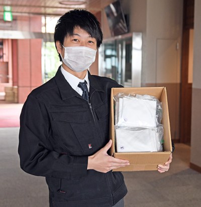 心のこもったマスクが送られ、手にする教務課職員