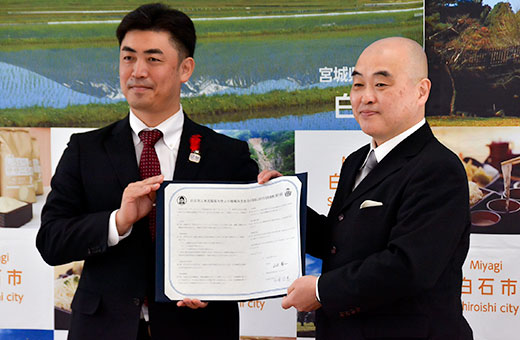 双方で署名した協定書を手にする山田市長と千葉学長(右)