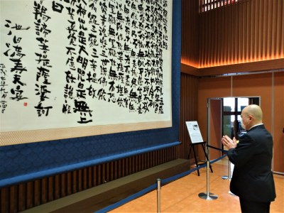 「般若心経写経」軸に合掌する千葉学長