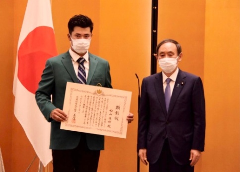内閣総理大臣顕彰状を手にした松山さん(左)と菅義偉総理大臣=写真提供:文部科学省