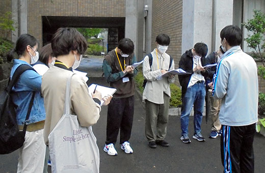 せんだんの丘職員の説明を聞き、メモを取る学生たち
