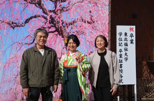 卒業式を終え、家族と写真を撮る卒業生
