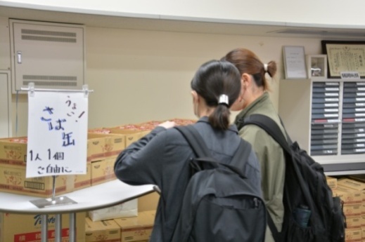 積まれたサバ缶をチェックする学生