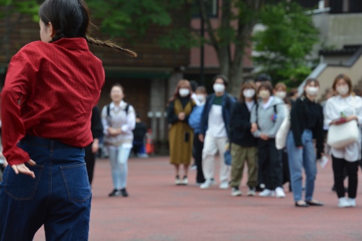 少し離れたところから見学する学生