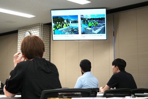 学生の報告を資料を見ながら熱心に聞く同窓会員