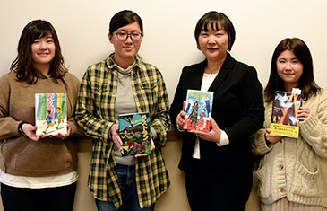 取材メンバーと佐々木さん(右から2人目)。著書を手に記念撮影