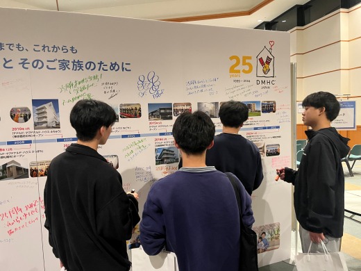 記念ボードのメッセージを見る学生