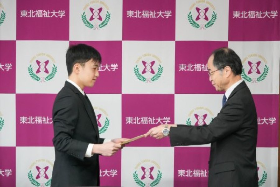 阿部副学長から表彰される新妻さん