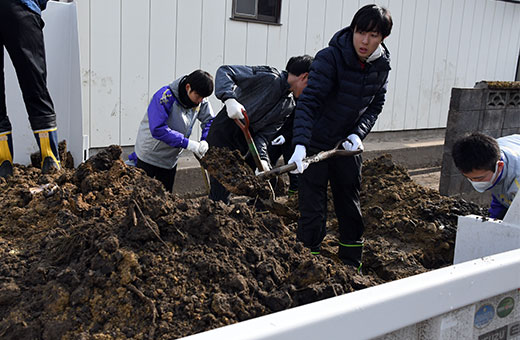 家屋からかき出した泥をトラックに載せる=11月27日、丸森町